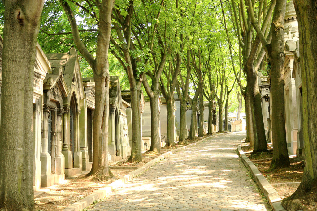 Von Bäumen gesäumte Wege auf dem Père-Lachaise-Friedhof.