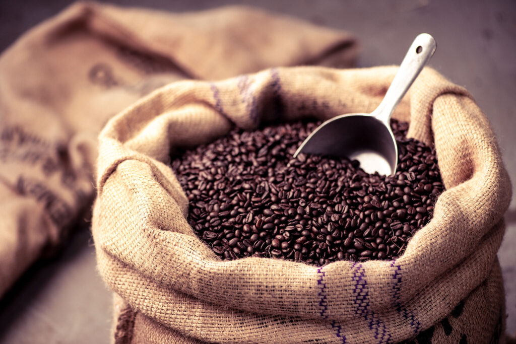 A burlap sack of dark coffee beans.