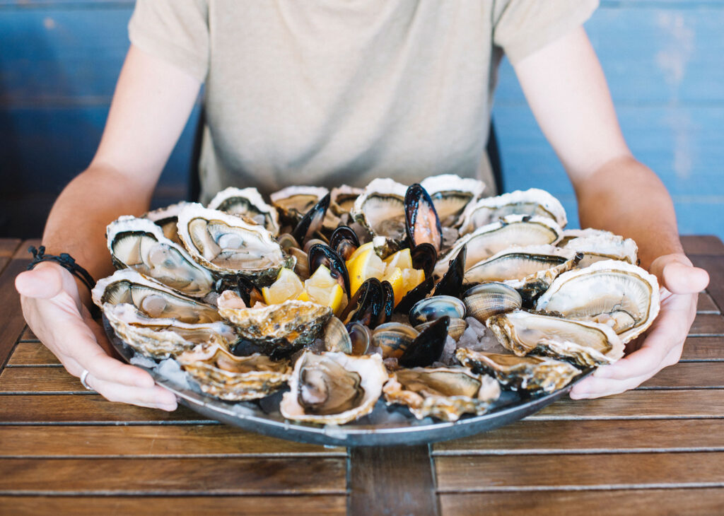 A full plate of mussels and oysters on the half shell.