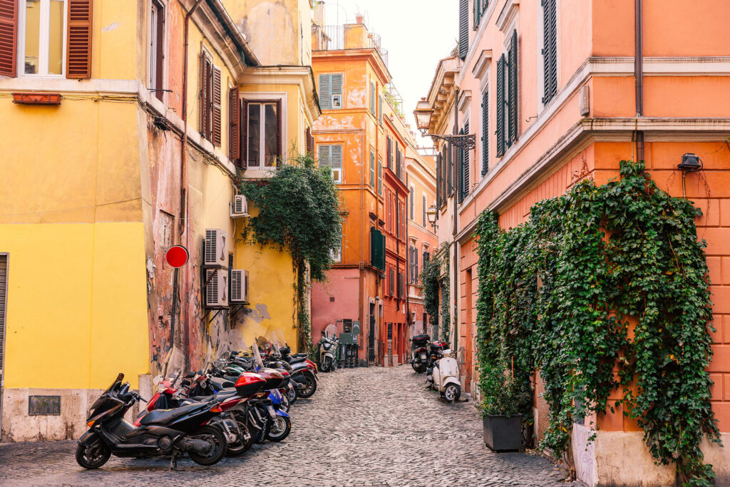 Scooters parked on cobblestones in the Trastevere neighborhood.