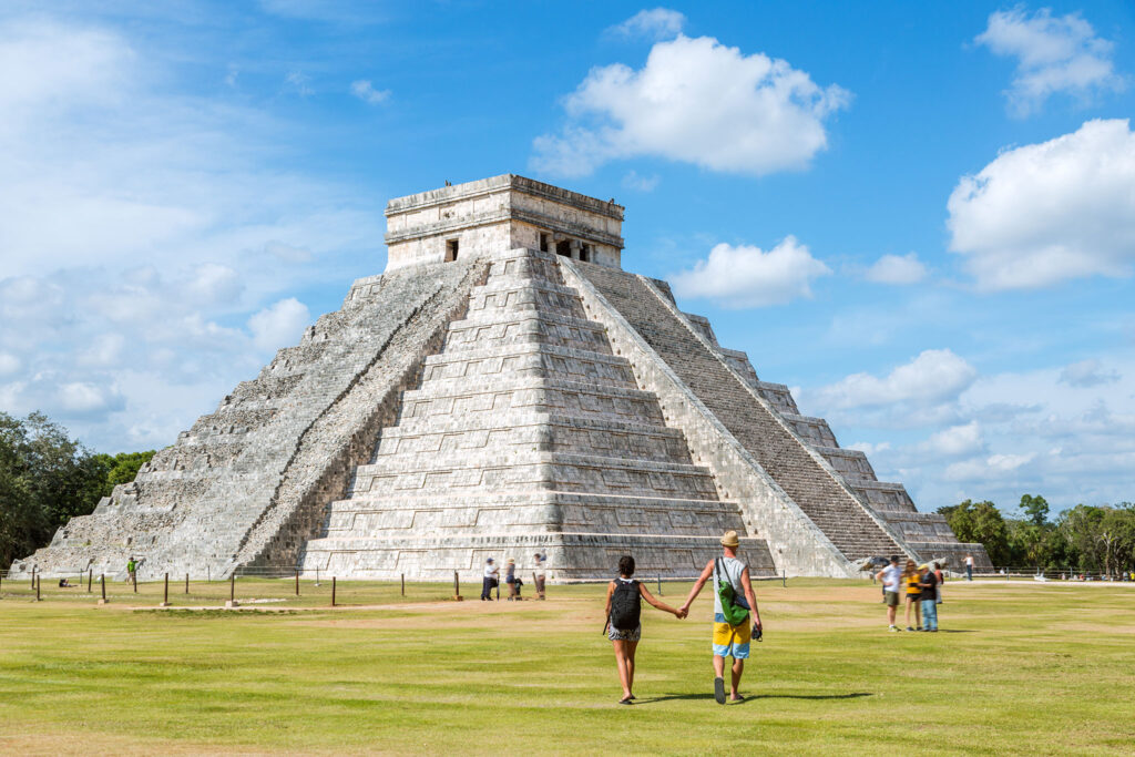 Tourists admire the ancient architecture of the El Castillo temple.