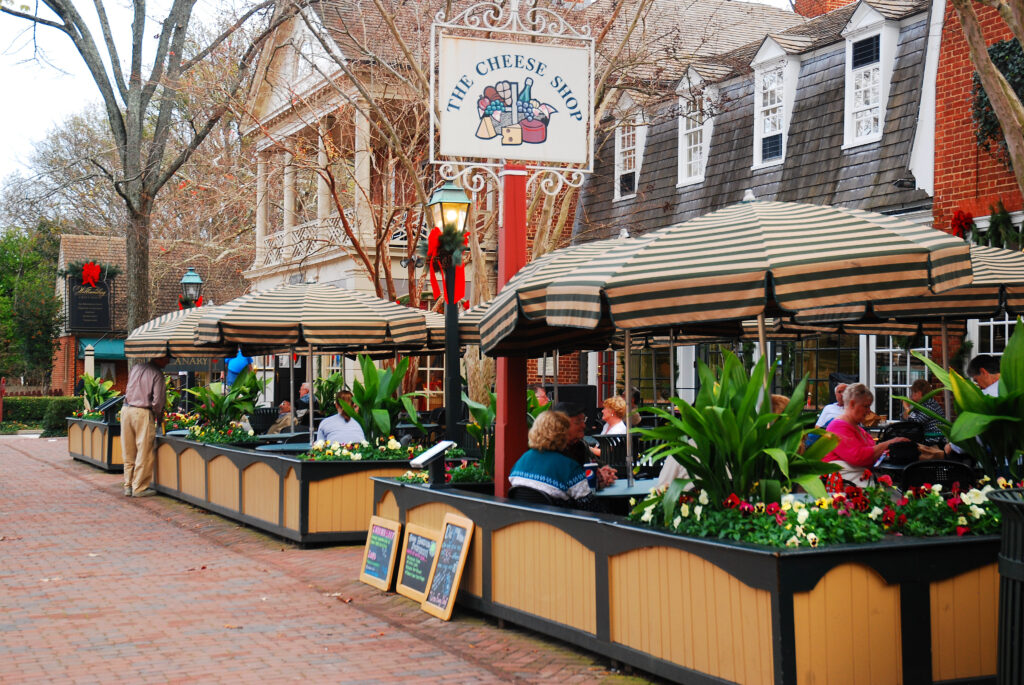 People enjoying an outdoor meal in Merchants Square, Williamsburg, Virginia, on a sunny December day.